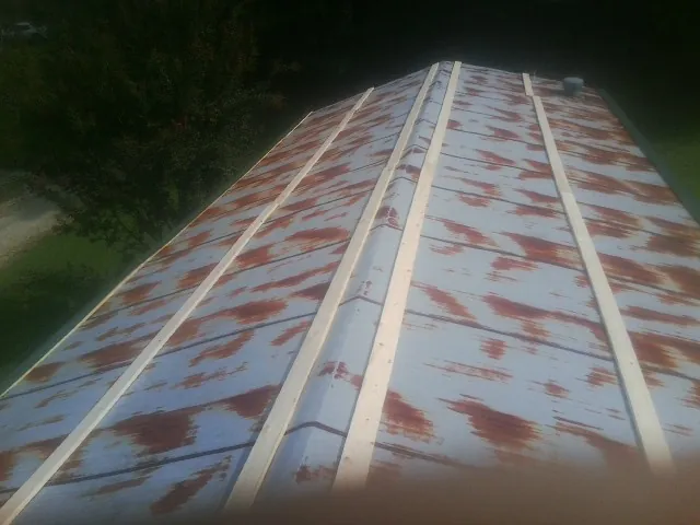 Rusted metal roof panels with new wood purlins before replacement — Storm Damage Roof Repair in Satellite Beach by Roofing Brothers