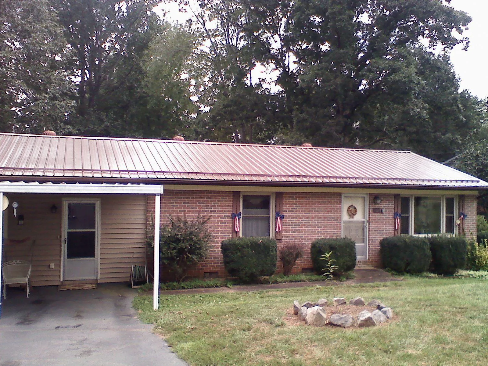 Bronze metal roof and carport on a brick ranch home — Roof Repair work by our crew in Satellite Beach